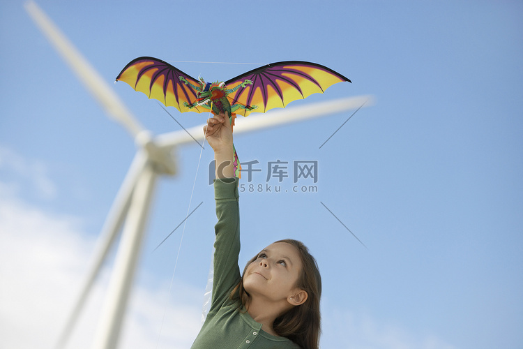 在风电场玩龙风筝的白人小女孩