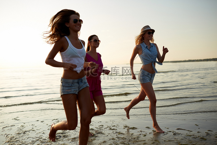 一群微笑的女人在沙滩上奔跑