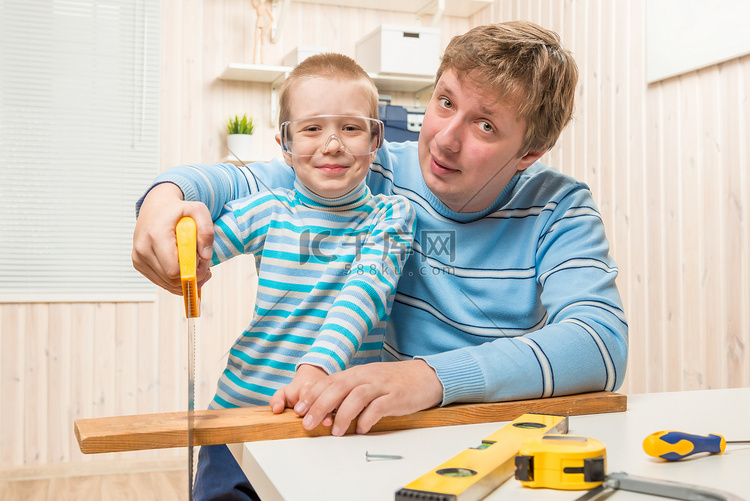 父亲教他的儿子切割木板锯