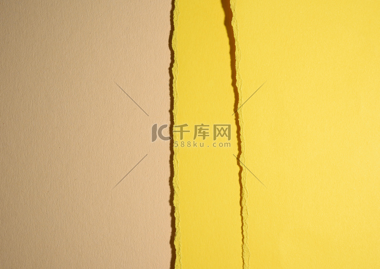 米色背景上黄色纸板撕裂的边缘，
