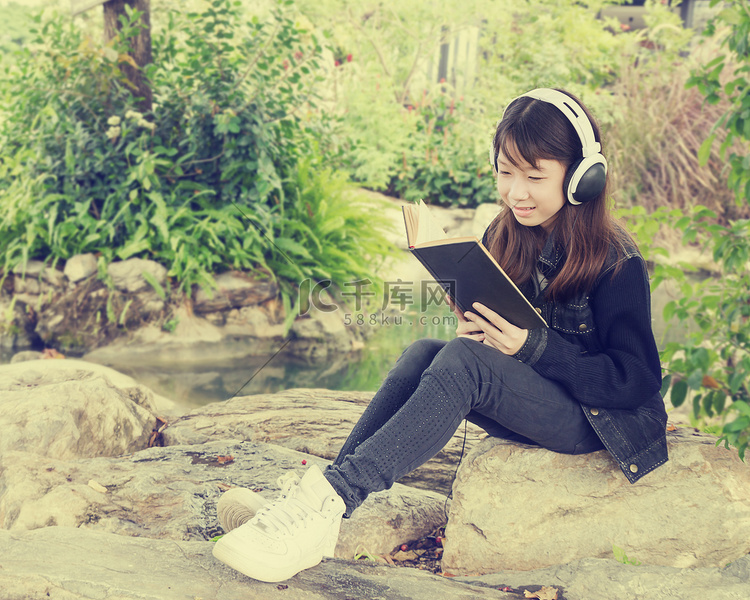 小女孩在公园看书听音乐