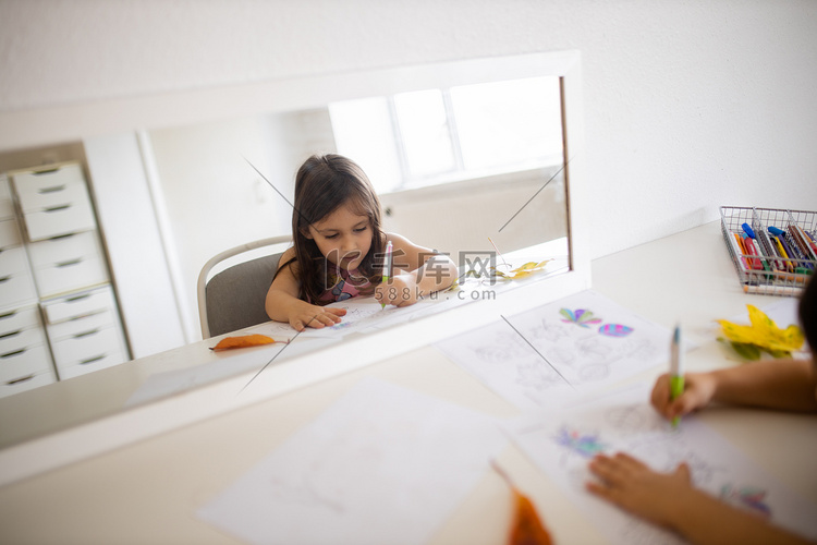 镜子映出一个小女孩用笔给不同类