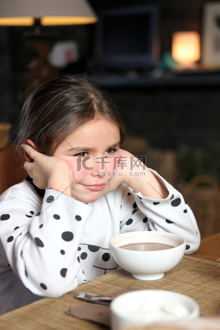 脾气暴躁的小女孩坐在热巧克力