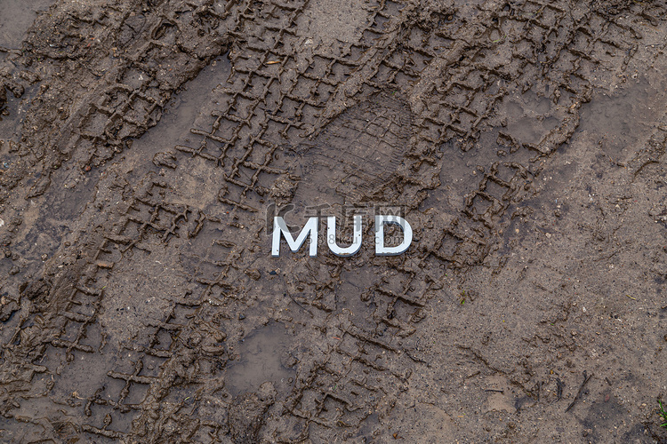 在潮湿的泥土表面铺上银色金属字
