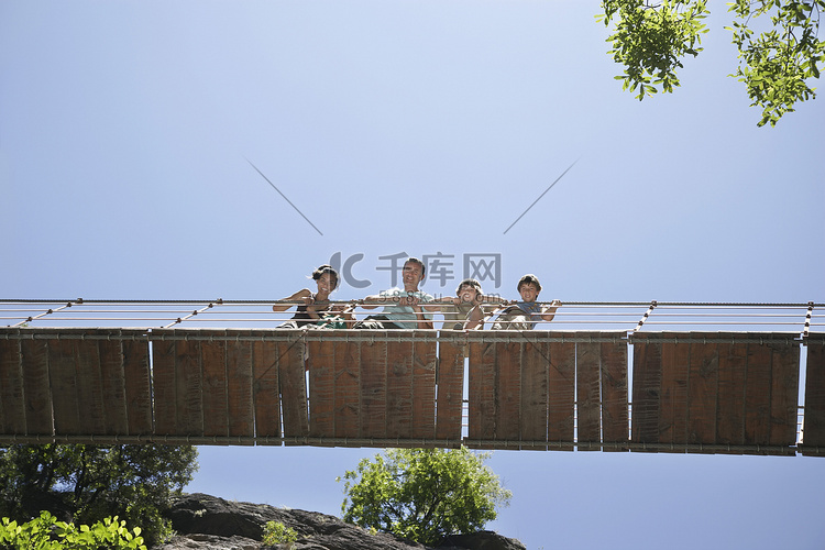 一对夫妇带着三个孩子从桥上俯视
