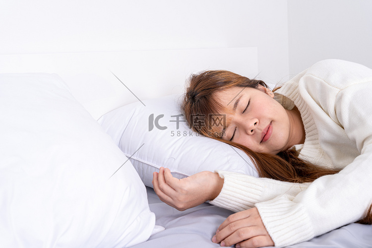 亚洲女人睡在床上，心情愉快地放