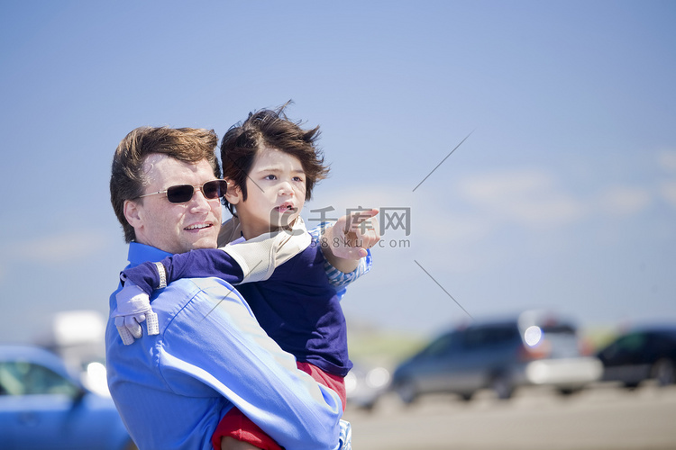 父亲抱着残疾的儿子在沙滩上