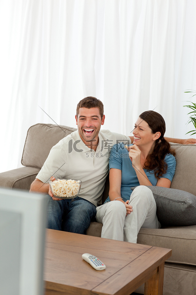 快乐的夫妇一边看喜剧电影一边吃