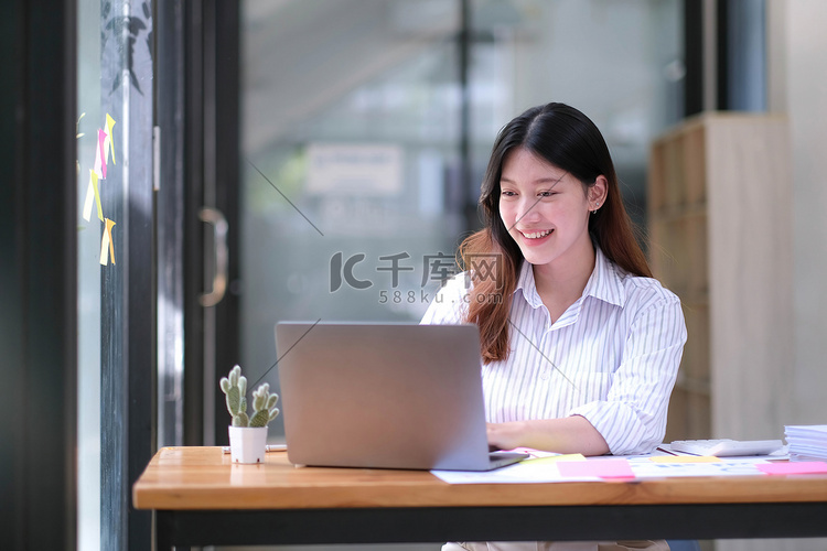 亚洲女商人使用笔记本电脑，在办