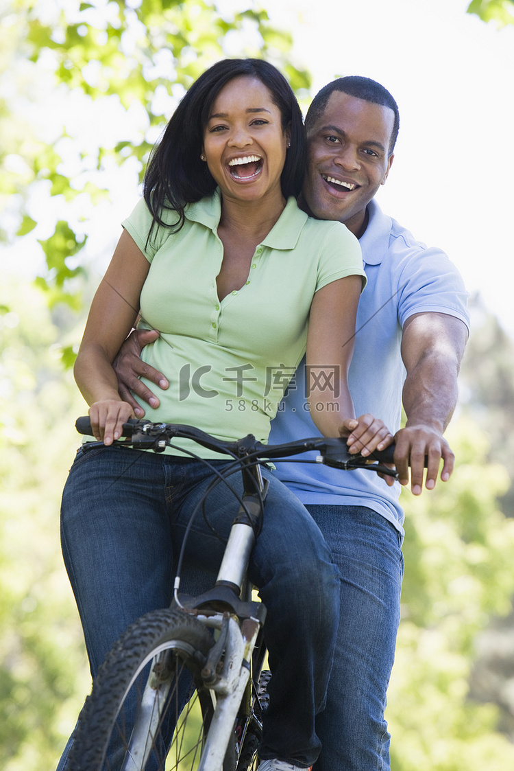 夫妇在户外微笑着骑自行车