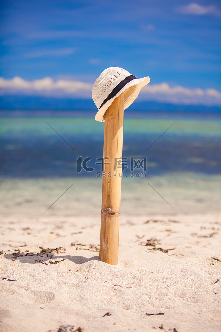 白色沙滩上木栅栏上的草帽，享有