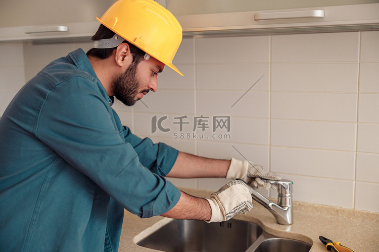 男性水管工在客户厨房修理水槽水