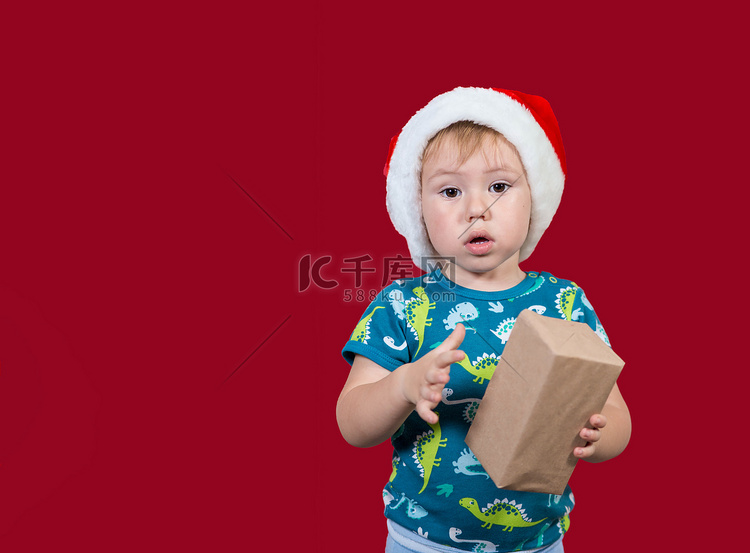 一个小男孩试图打开新年礼物的包