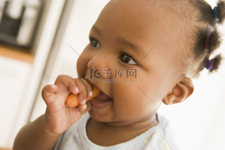 年轻女孩在室内吃胡萝卜