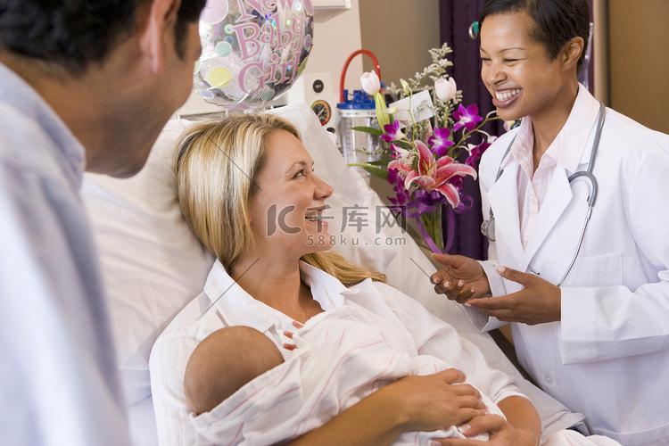 有孩子的新父母与医生交谈并微笑
