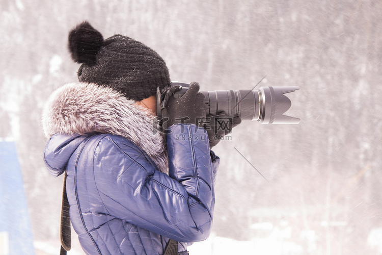 冬天在暴风雪中用带长焦镜头的单