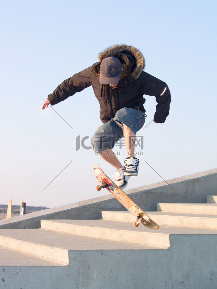 年轻的少年用他的滑板做特技