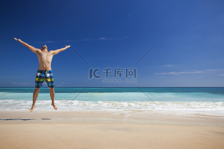 男子在沙滩上跳跃