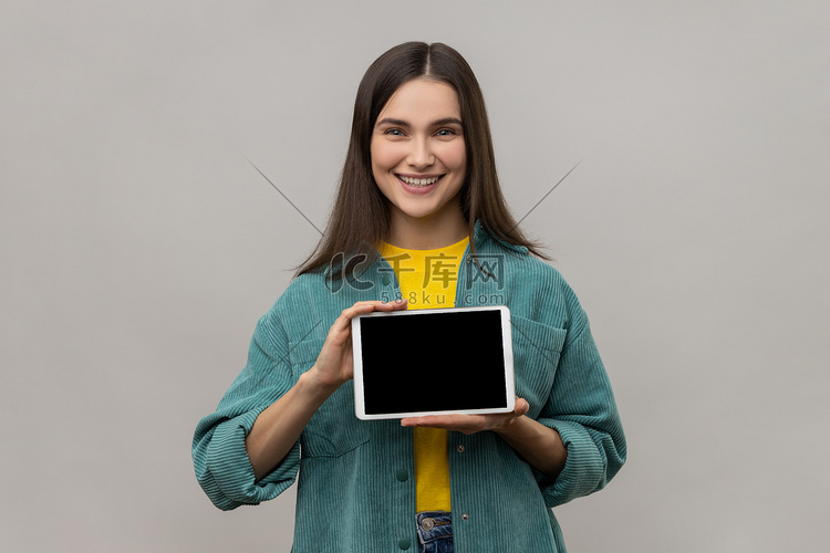 女人手里拿着数字平板电脑，向相