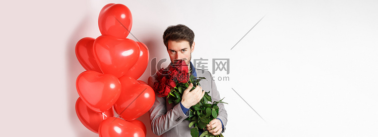 浪漫的男人闻到一束红玫瑰，热情