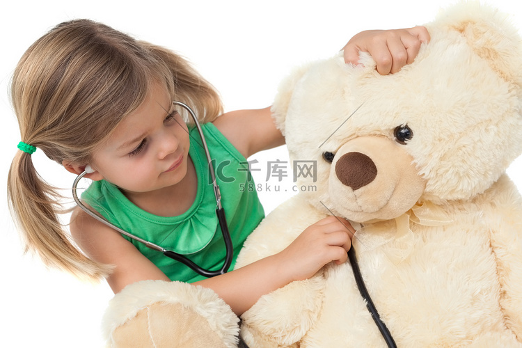 可爱的小女孩和她的泰迪熊一起玩