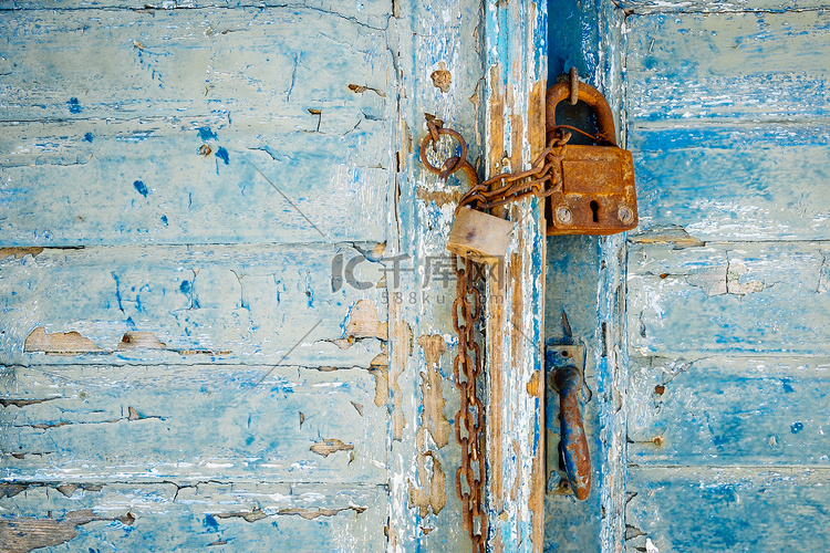 风化纹理门上的旧生锈挂锁和链条