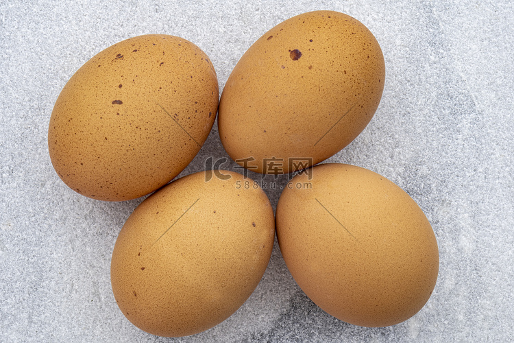 大理石台面上四个棕色斑点鸡蛋的