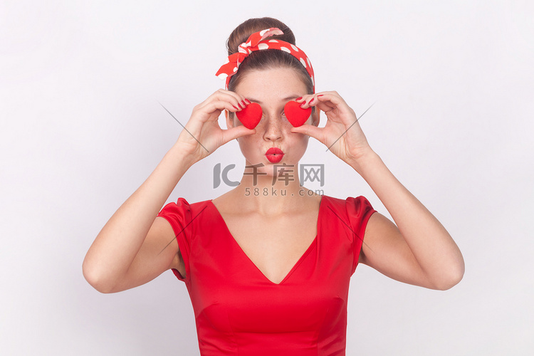 浪漫的女人用小红心遮住眼睛，这