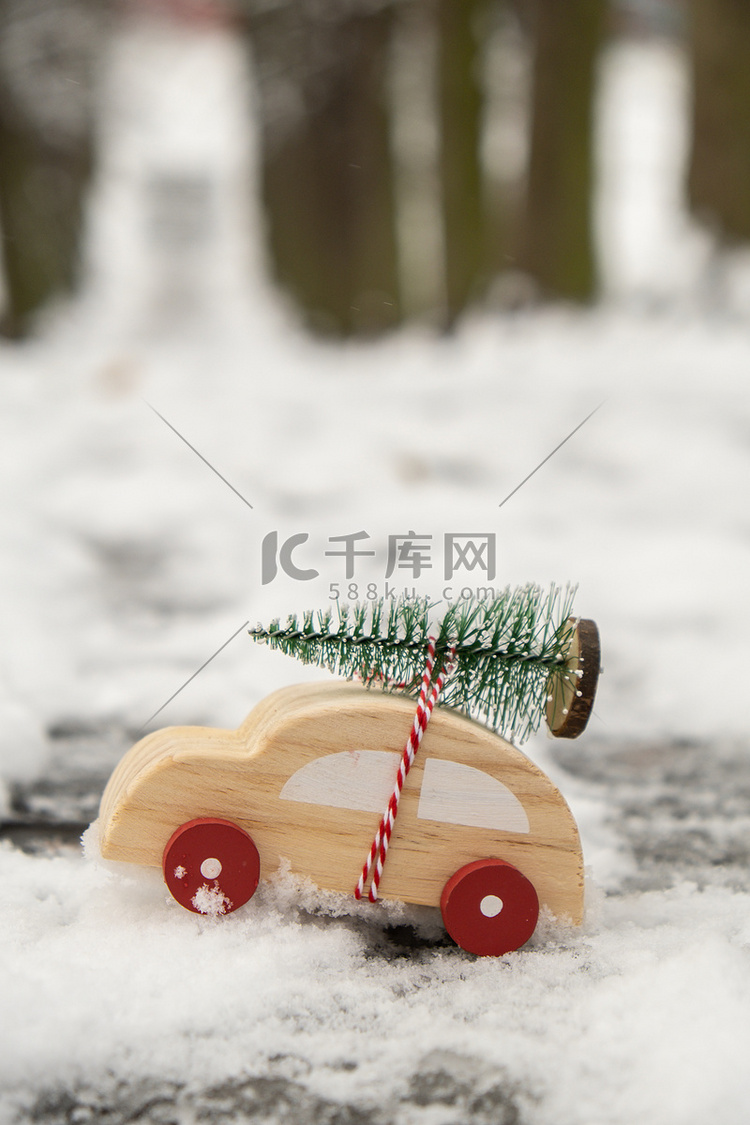 雪地上载着圣诞树的木制汽车。