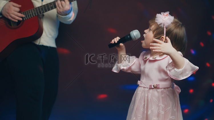 穿着复古裙子的小女孩在舞台上唱