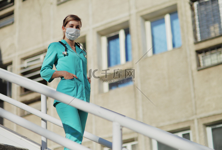 戴防护面罩的女医生或护士走上楼