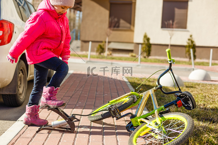 一个小女孩给自行车轮胎打气