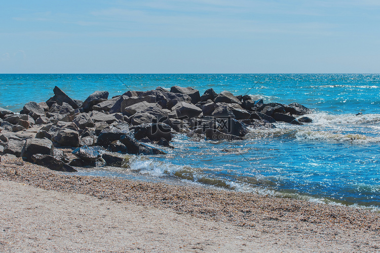 在海岸的防波堤海滩石头与小波浪