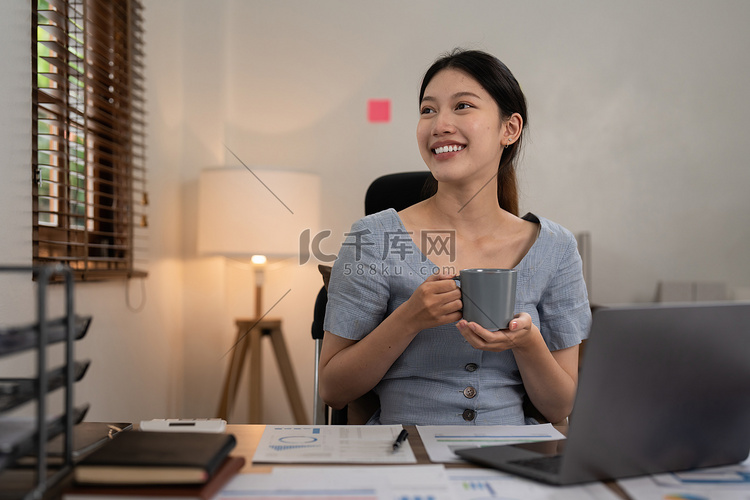 在家使用笔记本电脑的亚洲女性。