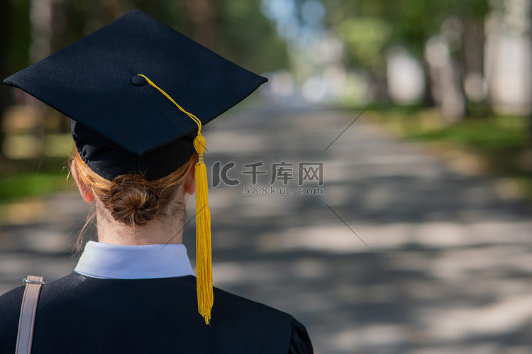 一位女士将她的毕业帽扔向蓝天。