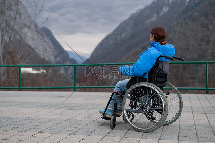 一个坐在轮椅上的女人在欣赏高山