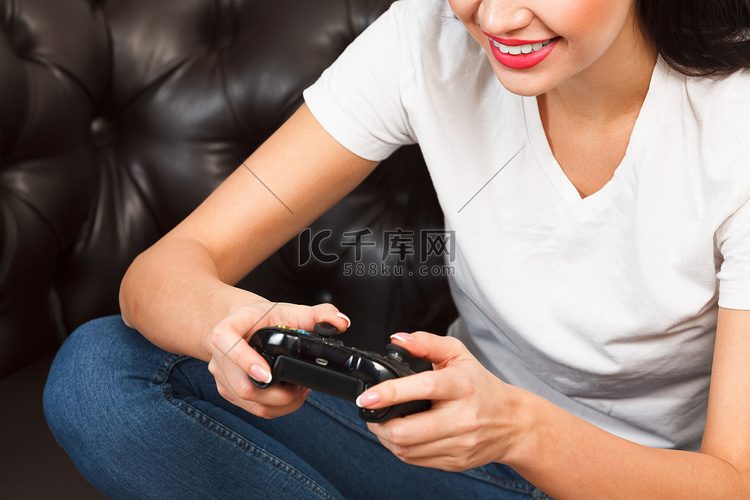 坐在棕色皮沙发上玩视频游戏的女