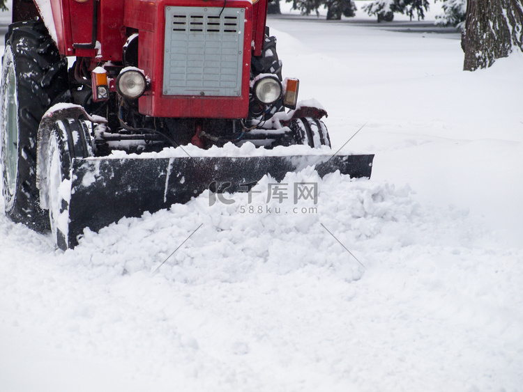 拖拉机在降雪后从城市公园的人行