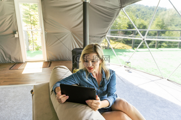 圆顶帐篷里拿着平板电脑的女人