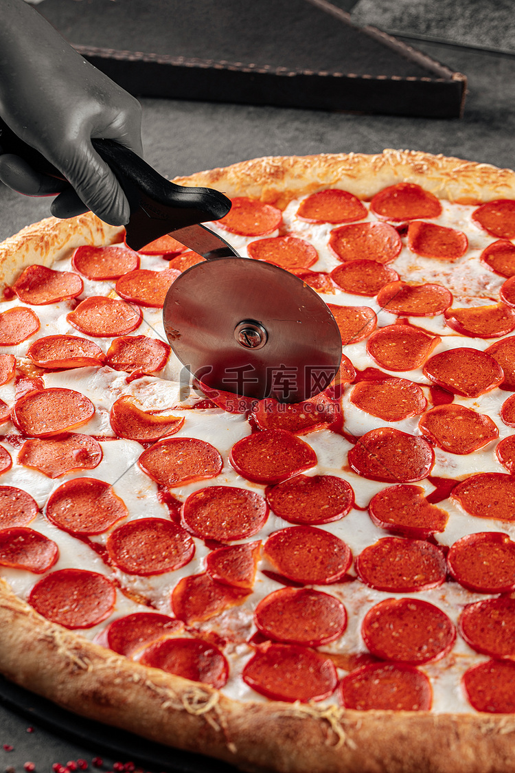 用专用刀切巨型意大利辣香肠披萨