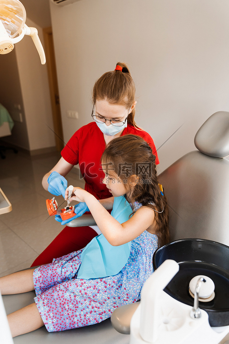 牙医向孩子展示如何正确使用牙刷