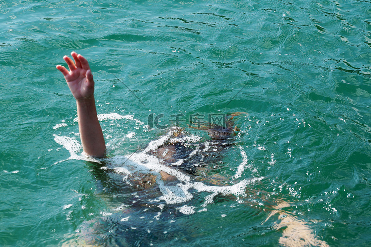 溺水的女孩将她的手举出水面。