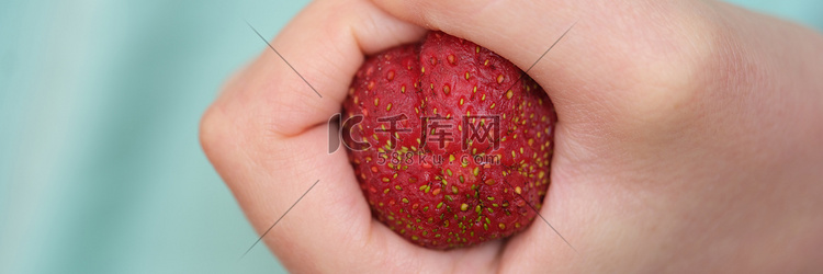 以结肠便秘形式握紧拳头的草莓