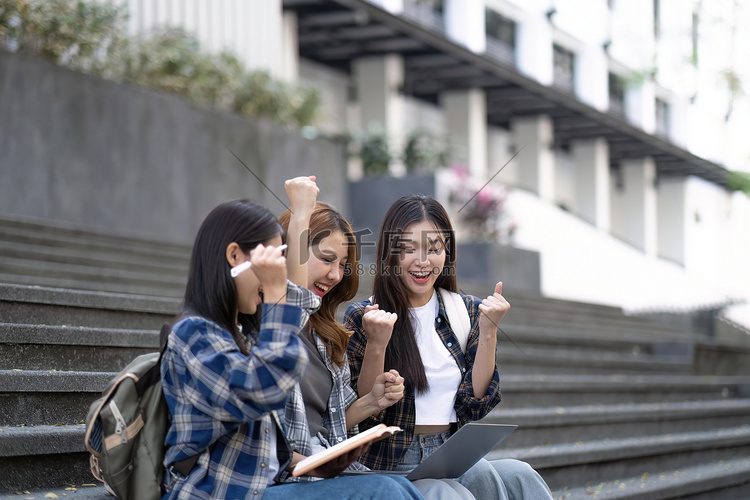 漂亮的年轻学生在课后坐在户外使