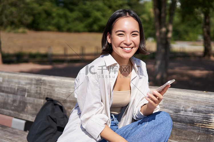 快乐的亚洲年轻女性在公园里用手