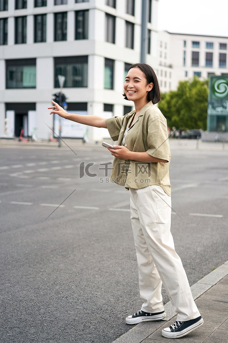 垂直拍摄的年轻女性试图赶出租车