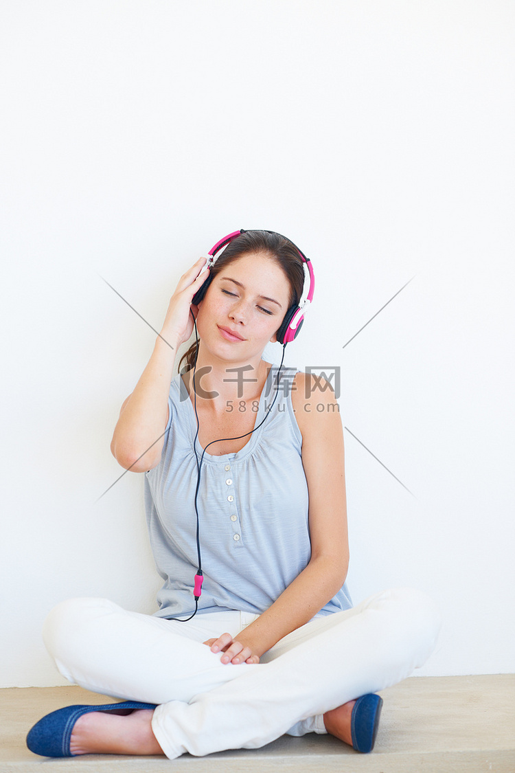 放松，音乐和女人在地板上戴着耳