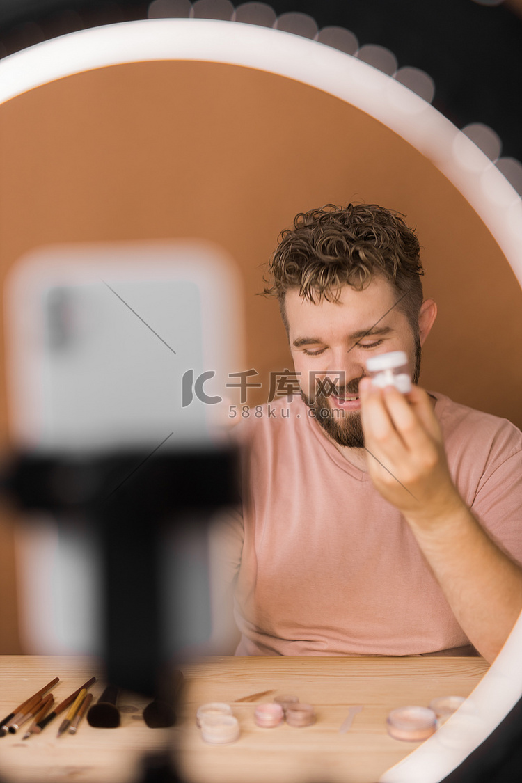 男性美容博主化妆并用手机录制视