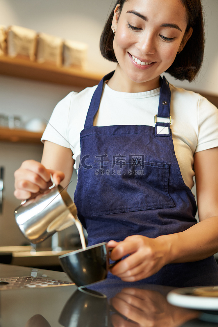 黑发亚洲女孩咖啡师的垂直照片，