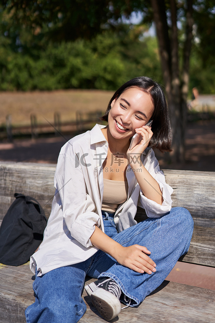 微笑的亚洲女孩在公园里放松，用